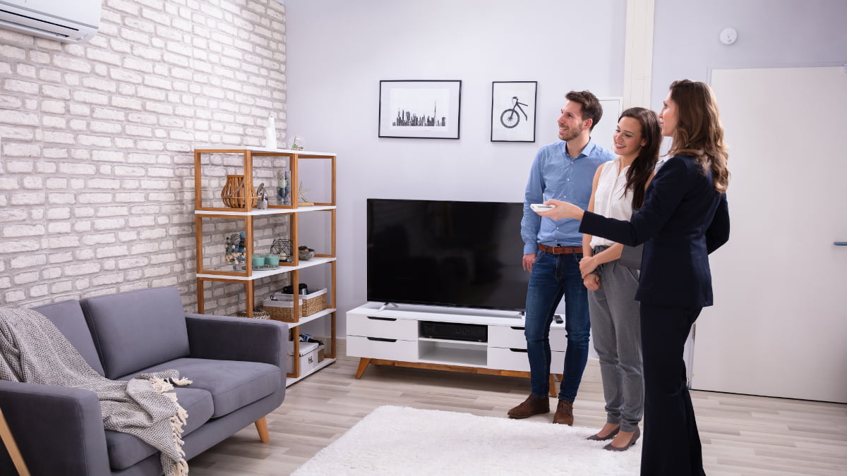 Couple and business woman look at split air conditioning system