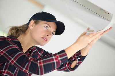 Air conditioning engineer inspects unit
