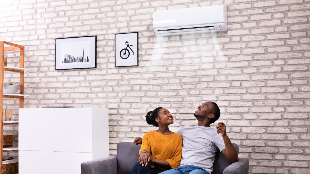 Young couple sit on their sofa and enjoy their climate control