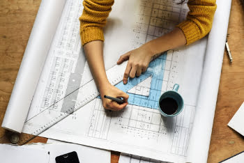 Woman draws on building plans
