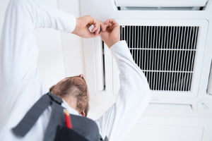 Reliable air conditioning installer works on a ceiling cassette air conditioning unit