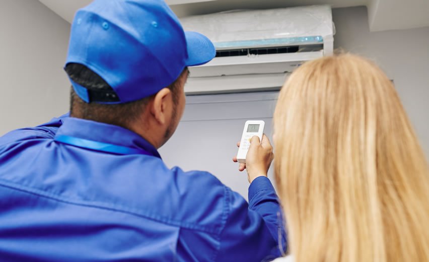 Air con installer showing customer how to use Air con unit