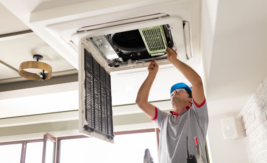 Engineer repairing air conditioning unit