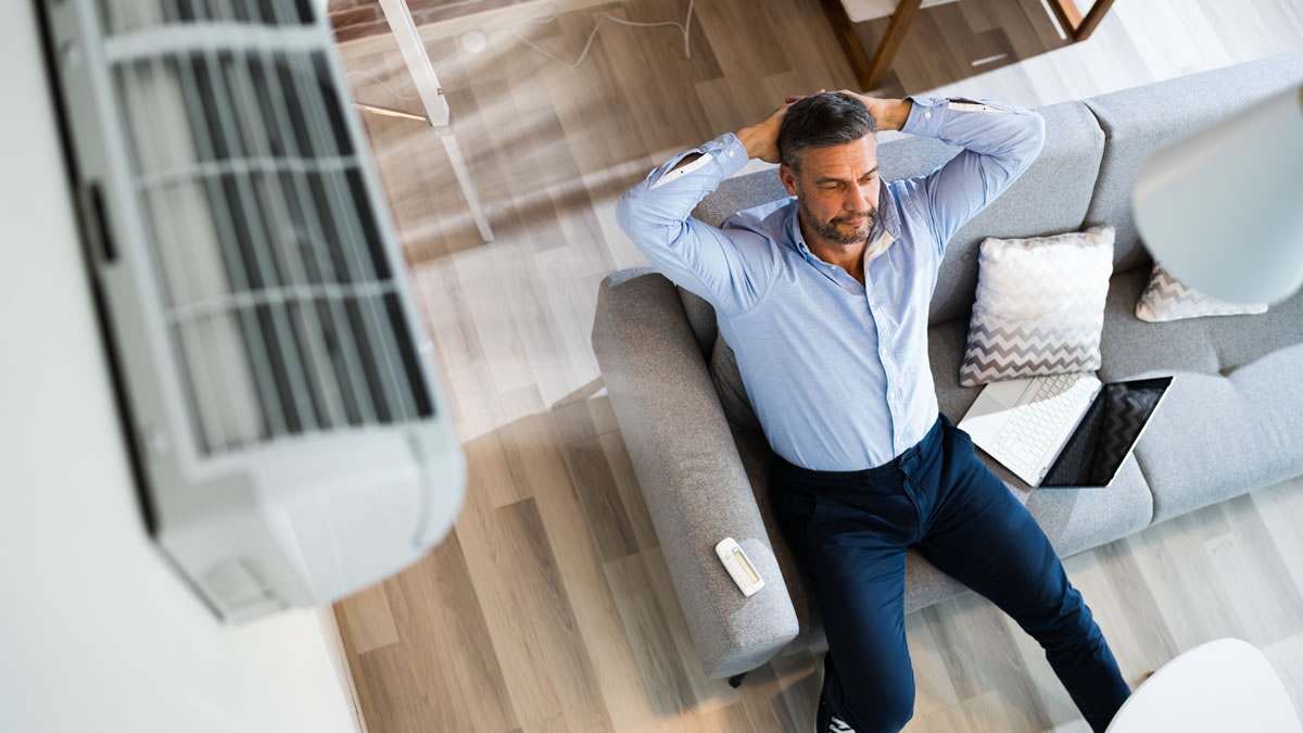 Overhead view of person sat on sofa underneath an air con unit